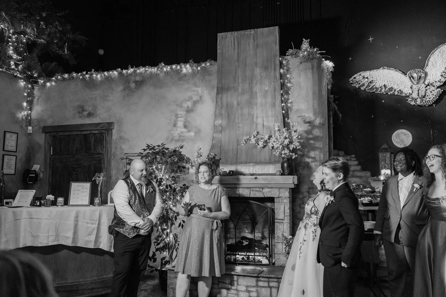 Sydney and Hannah Rusow laugh with guests near a stone fireplace at Halfway House in Boulder, CO.
