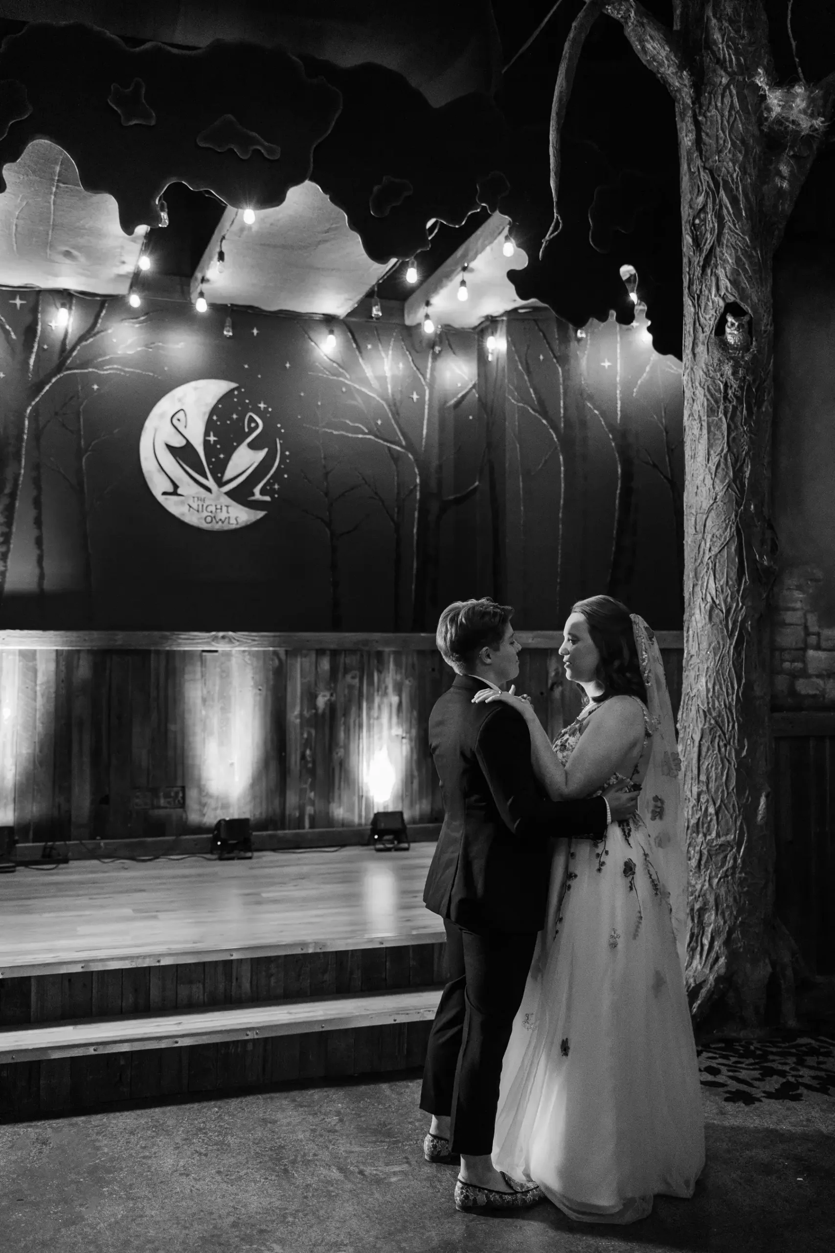 Sydney and Hannah Rusow share an intimate moment near a tree column at Halfway House in Boulder, CO.
