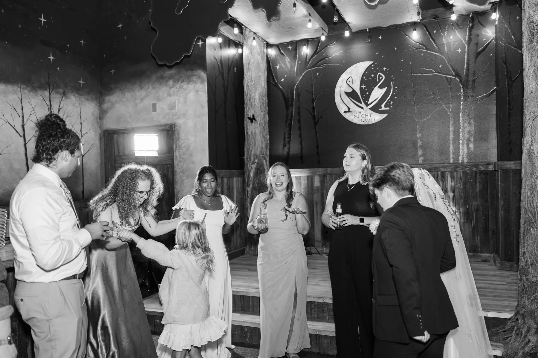 Guests dance and mingle near the stage at Sydney and Hannah Rusow's wedding reception at Halfway House in Boulder, CO.