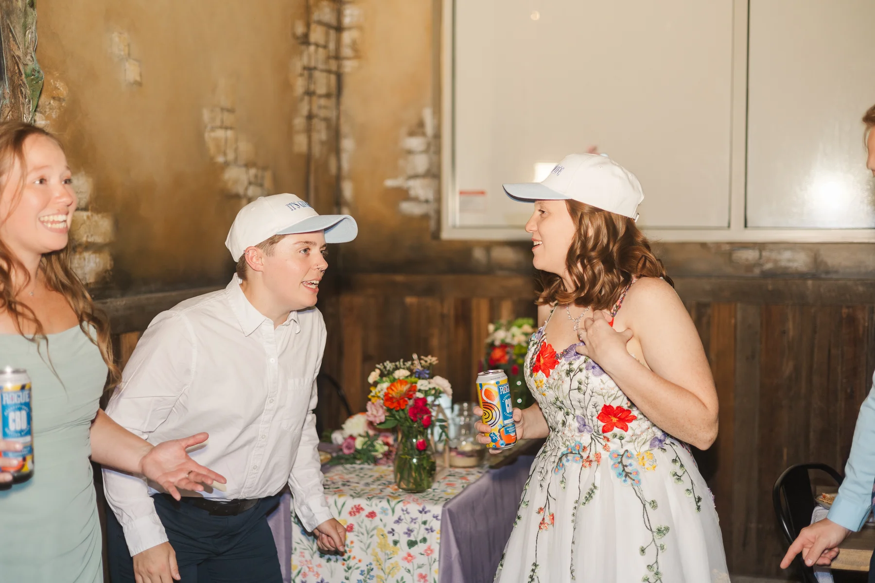 Sydney and Hannah Rusow in matching white caps share a joyful moment with guests at Halfway House in Boulder, CO.