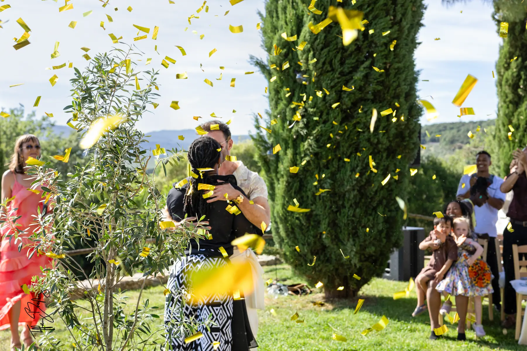 Two grooms share their first kiss amid a shower of gold confetti at Conti di San Bonifacio Wine Resort in Tuscany.