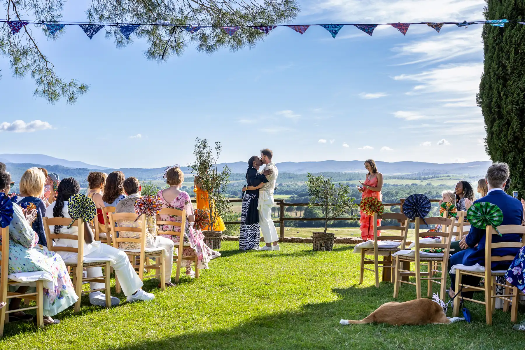 Two grooms share their first kiss at an outdoor ceremony at Conti di San Bonifacio Wine Resort in Tuscany, Italy.