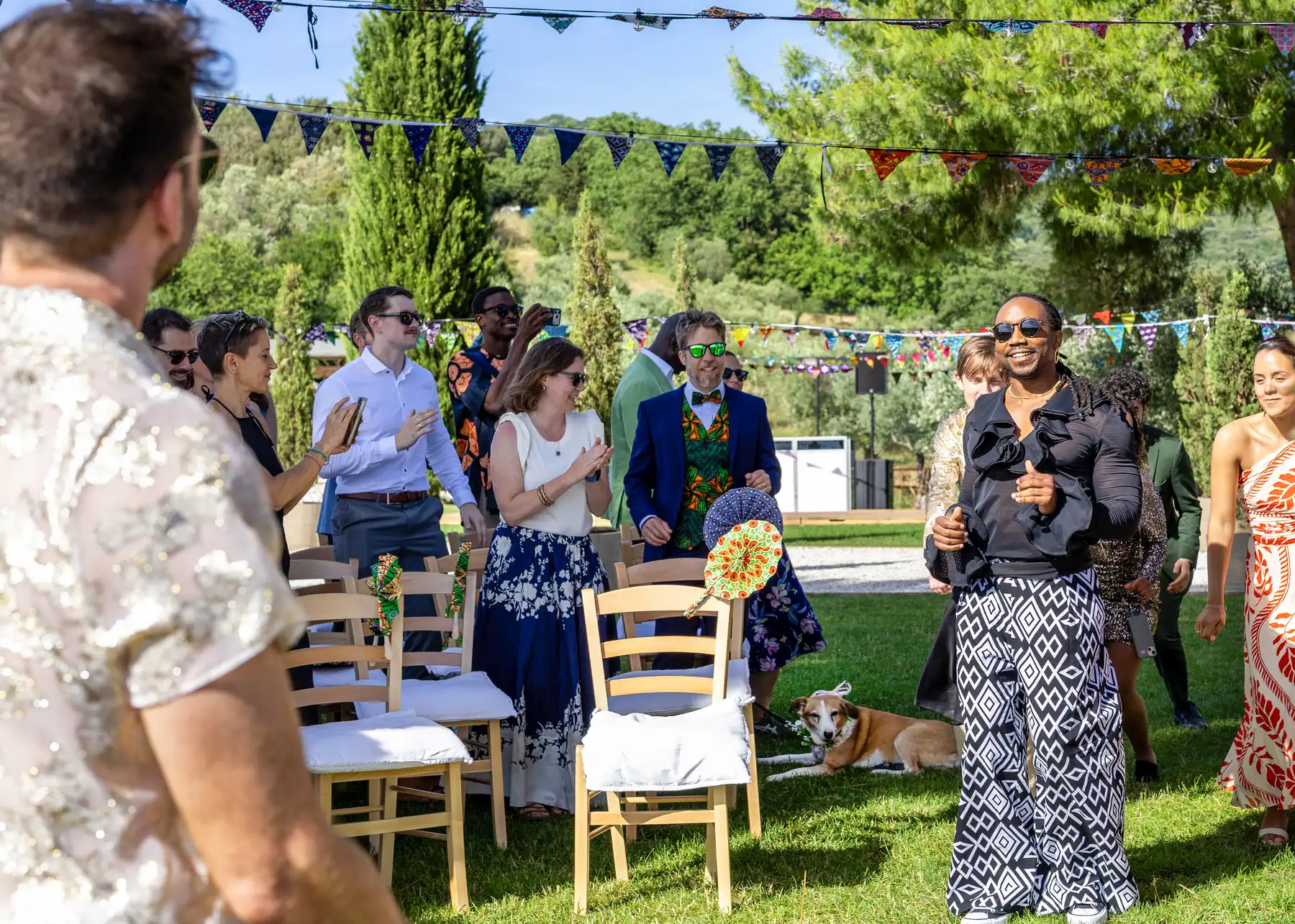 Wedding guests applaud and celebrate as a groom walks the aisle at Conti di San Bonifacio Wine Resort in Tuscany.