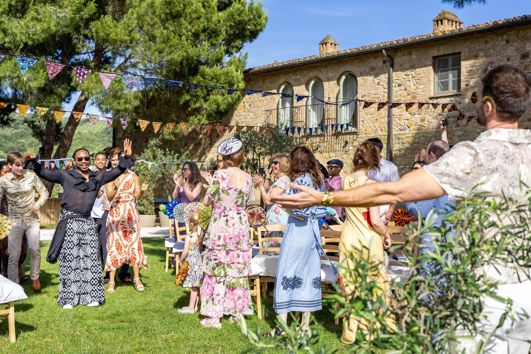 Guests dance and celebrate outdoors at Conti di San Bonifacio Wine Resort in Tuscany during a joyful wedding reception.